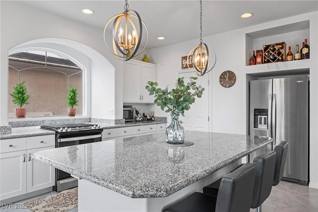 kitchen featuring a kitchen breakfast bar, a notable chandelier, a kitchen island, and stainless steel appliances