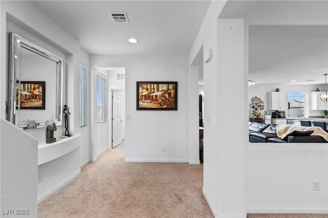 hallway featuring recessed lighting, baseboards, visible vents, and light carpet