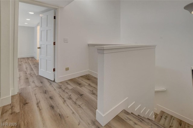 hallway featuring baseboards and wood finished floors