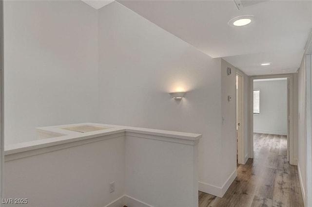 hallway with light wood-type flooring and baseboards