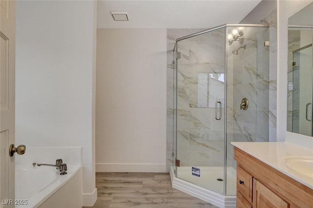 full bath featuring vanity, a garden tub, wood finished floors, and a shower stall