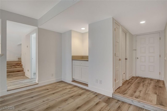 interior space featuring stairs, recessed lighting, baseboards, and light wood finished floors