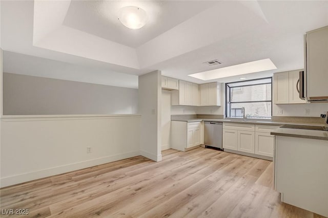 kitchen with visible vents, baseboards, light wood-style flooring, appliances with stainless steel finishes, and a raised ceiling