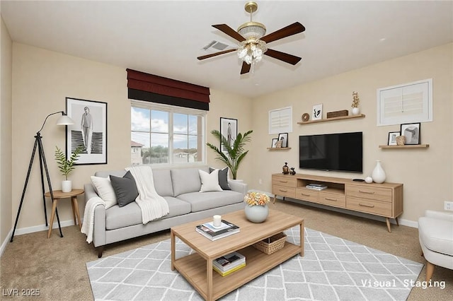 living area featuring baseboards, light carpet, and ceiling fan