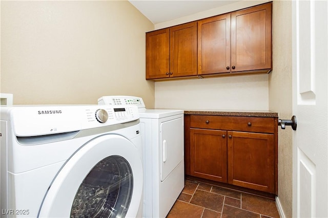 laundry area with cabinet space, independent washer and dryer, and stone finish floor