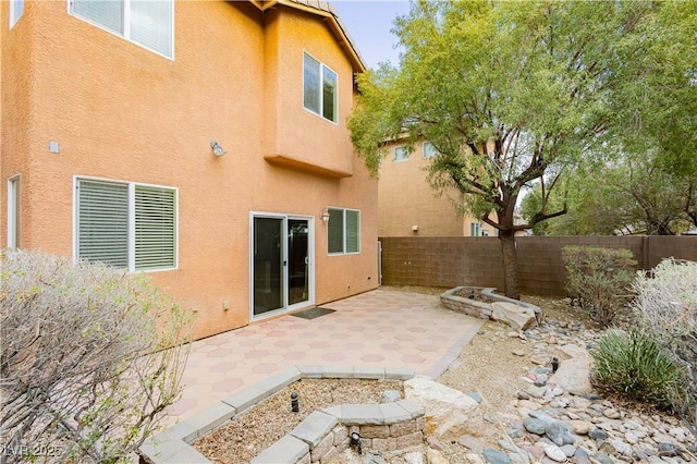 back of property with stucco siding, a patio area, and fence