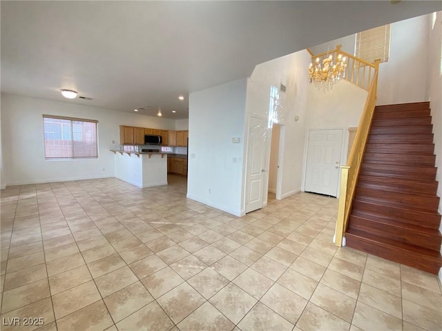 unfurnished living room with stairway, baseboards, light tile patterned flooring, recessed lighting, and a notable chandelier