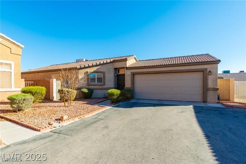 mediterranean / spanish-style house with stucco siding, a garage, concrete driveway, and a tile roof