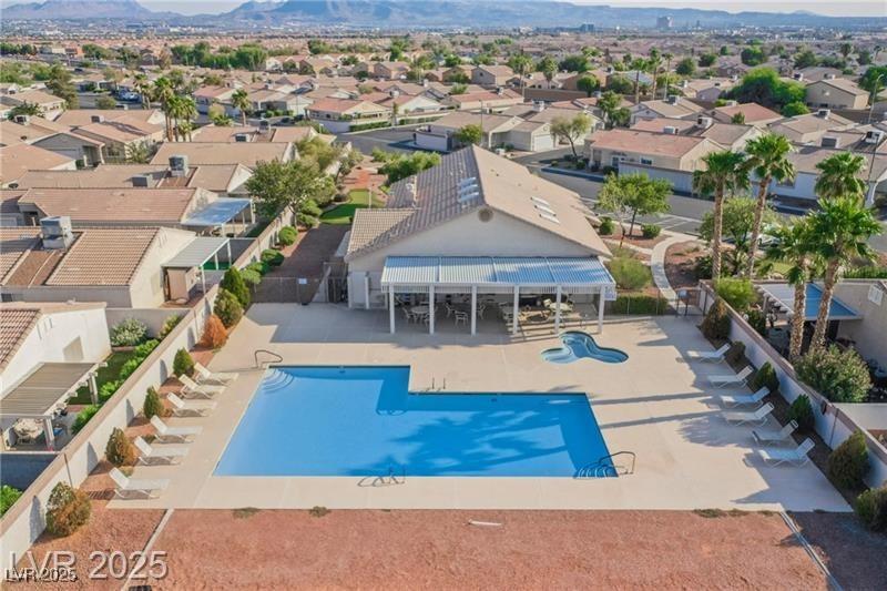 pool with a patio area, fence, a mountain view, and a residential view