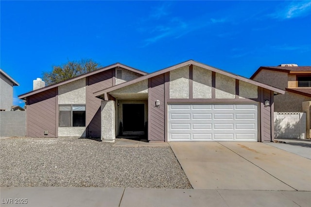 view of front facade with a chimney, an attached garage, concrete driveway, and fence