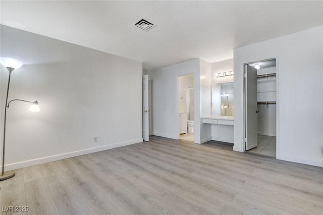 unfurnished bedroom with visible vents, baseboards, and wood finished floors