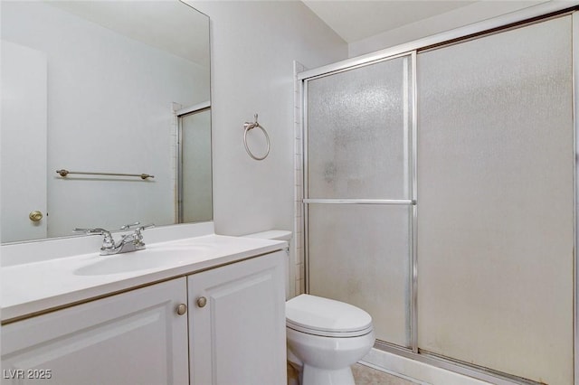 bathroom featuring vanity, toilet, and a stall shower