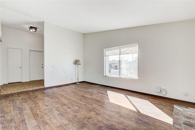 empty room featuring baseboards and wood finished floors