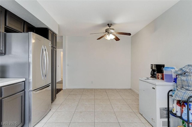 kitchen featuring light tile patterned flooring, light countertops, freestanding refrigerator, and ceiling fan