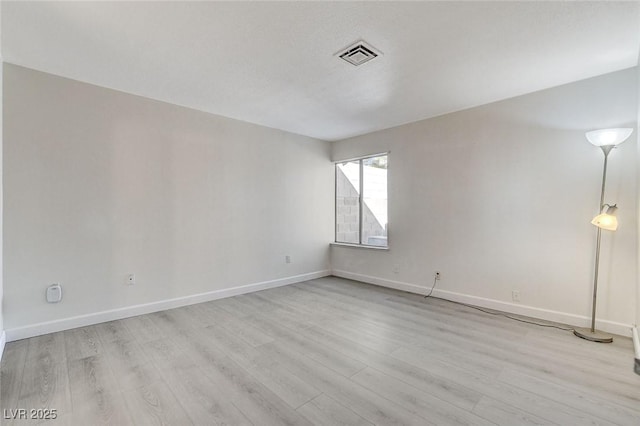 unfurnished room with light wood-style flooring, baseboards, and visible vents