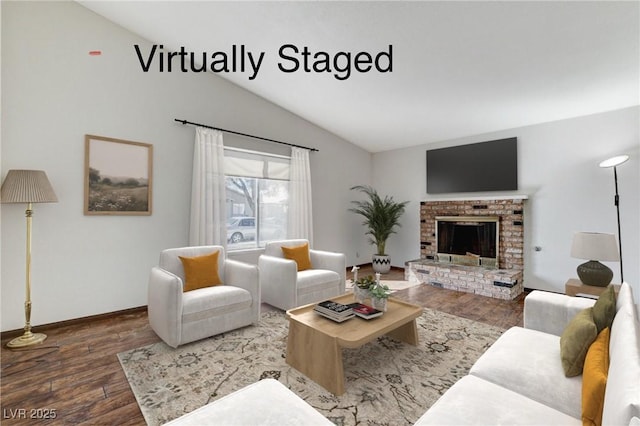 living room featuring lofted ceiling, a brick fireplace, wood finished floors, and baseboards