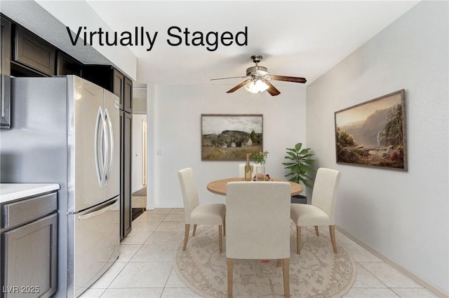 dining space featuring light tile patterned flooring, baseboards, and ceiling fan