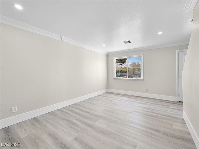 empty room with visible vents, light wood-type flooring, and ornamental molding
