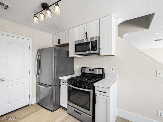 kitchen featuring visible vents, light wood-type flooring, light countertops, appliances with stainless steel finishes, and white cabinets