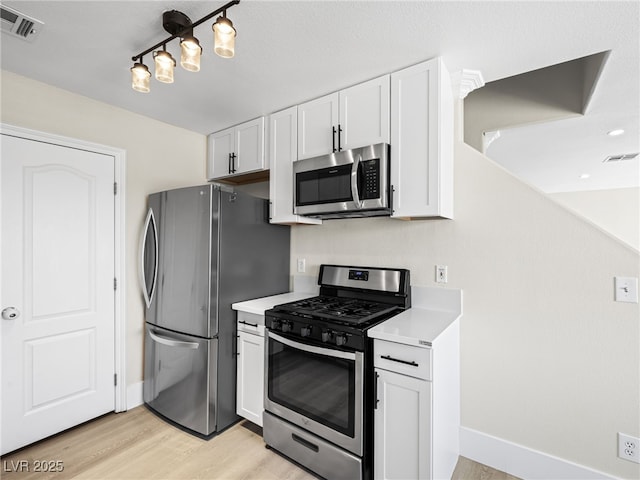 kitchen featuring visible vents, light countertops, light wood-style floors, white cabinetry, and stainless steel appliances