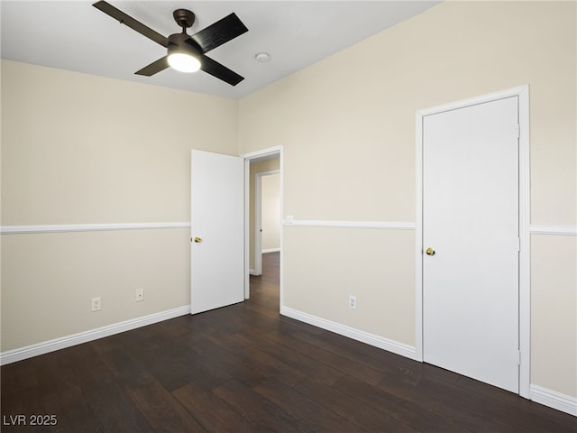 unfurnished bedroom with a ceiling fan, dark wood-style floors, and baseboards