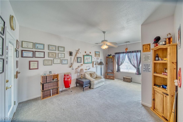 sitting room featuring baseboards, carpet floors, a textured ceiling, and ceiling fan