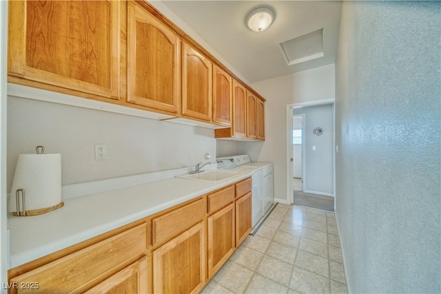 kitchen with light countertops, separate washer and dryer, baseboards, and a sink