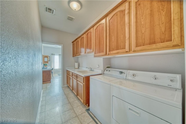 laundry area with washer and clothes dryer, visible vents, cabinet space, and a sink