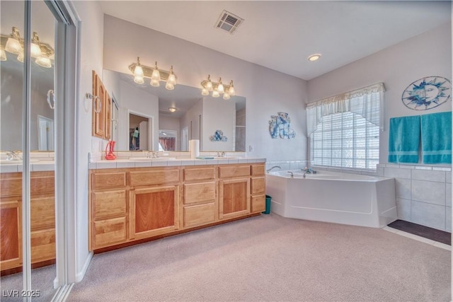 bathroom with a garden tub, carpet flooring, visible vents, and a sink