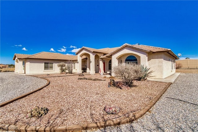 mediterranean / spanish house with stucco siding and a tile roof