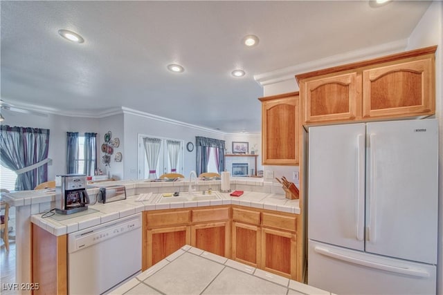 kitchen featuring white appliances, a peninsula, recessed lighting, a sink, and open floor plan