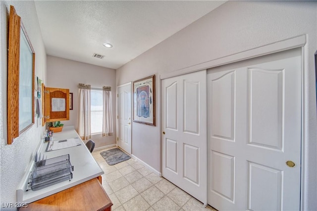 bathroom with visible vents, baseboards, and a textured ceiling