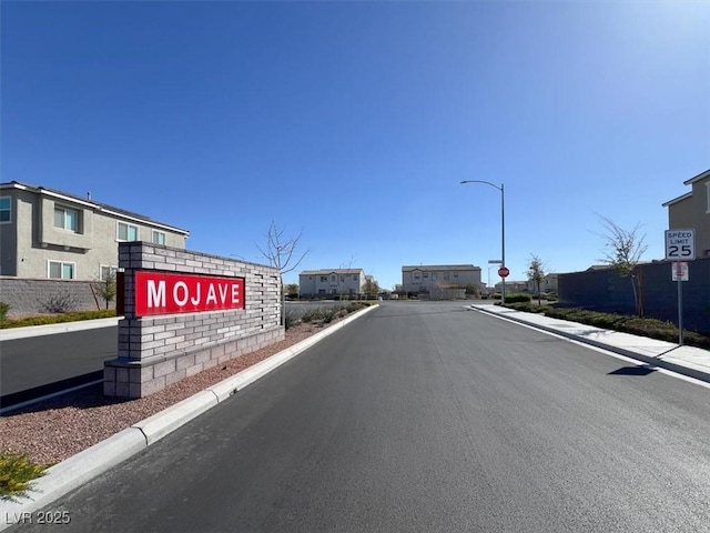 view of road with traffic signs, curbs, street lights, and sidewalks