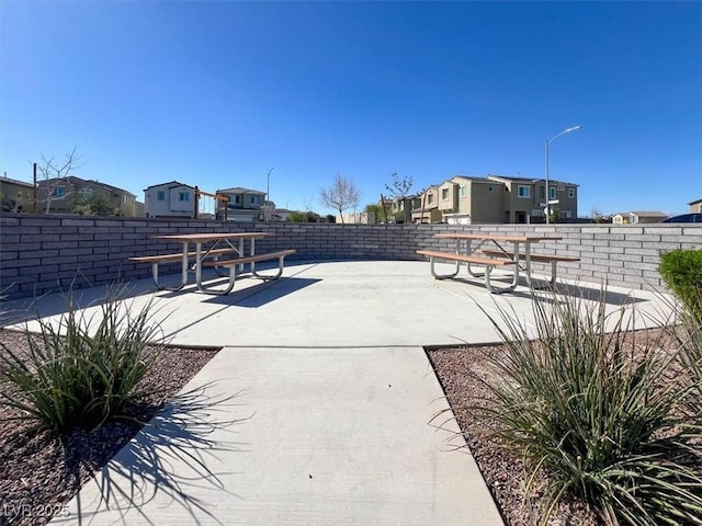 view of patio / terrace featuring fence and a residential view