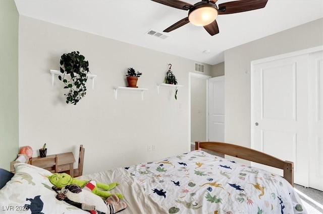 carpeted bedroom featuring a ceiling fan, visible vents, and a closet