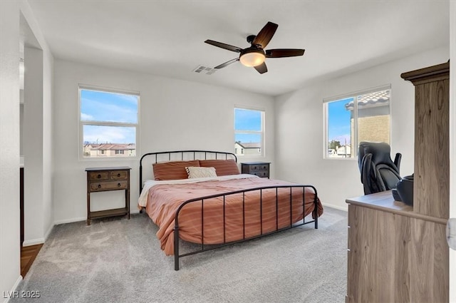 carpeted bedroom featuring visible vents, baseboards, and ceiling fan