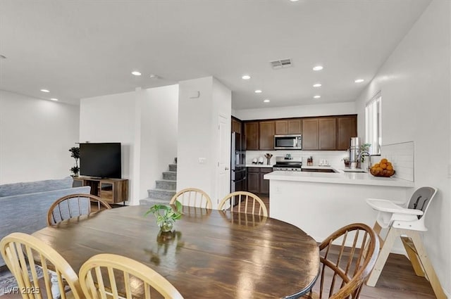 dining space with stairway, light wood-style flooring, recessed lighting, and visible vents