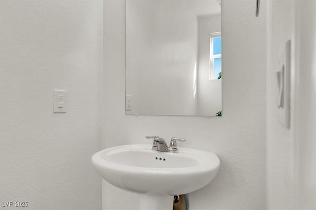 bathroom with a textured wall and a sink