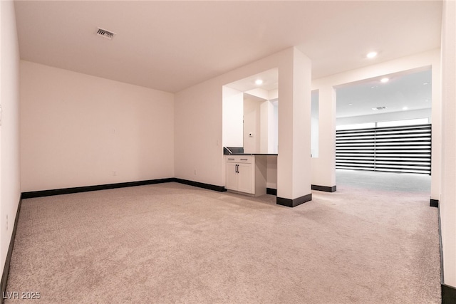 empty room with light carpet, visible vents, recessed lighting, and baseboards