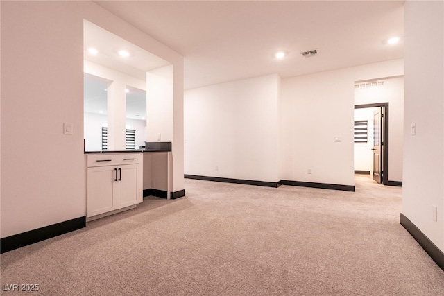 unfurnished living room with recessed lighting, visible vents, light carpet, and baseboards