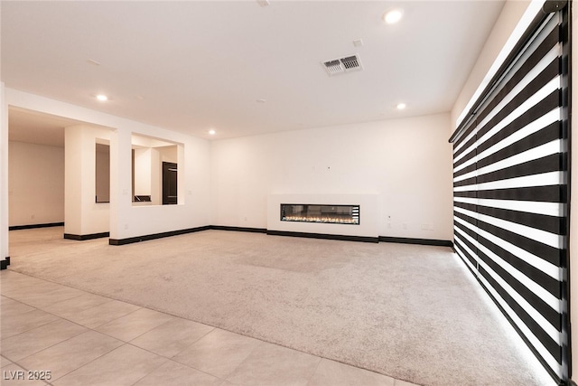 unfurnished living room featuring recessed lighting, visible vents, baseboards, and light colored carpet