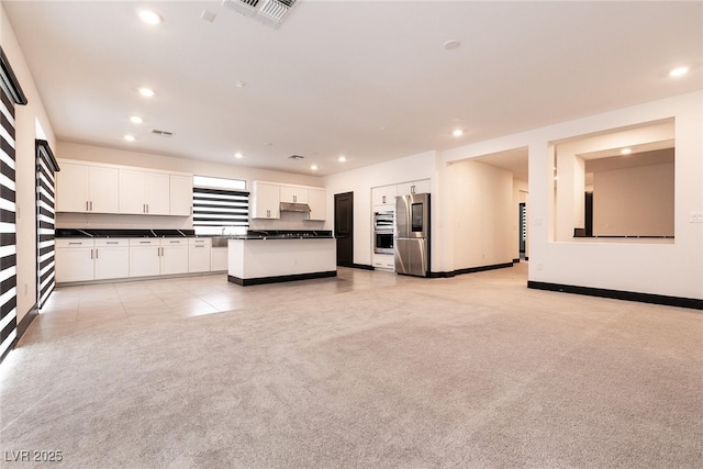 kitchen featuring visible vents, recessed lighting, appliances with stainless steel finishes, dark countertops, and light colored carpet