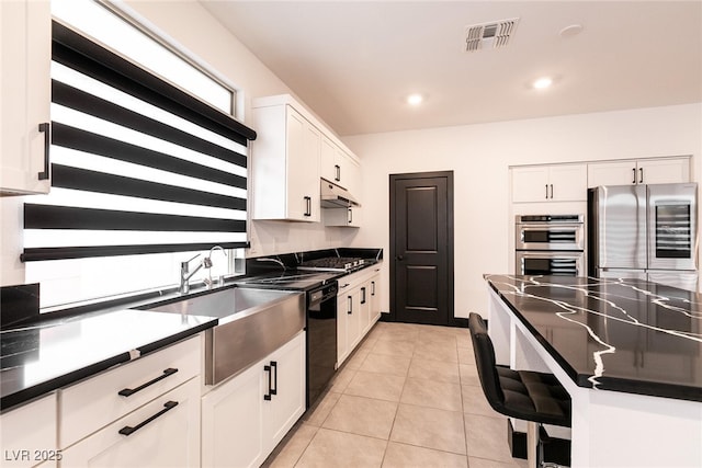 kitchen with under cabinet range hood, white cabinets, visible vents, and appliances with stainless steel finishes