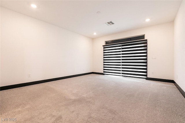 empty room featuring recessed lighting, carpet flooring, baseboards, and visible vents