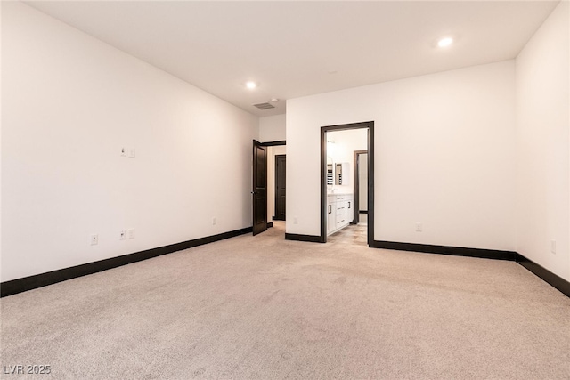 empty room with recessed lighting, light colored carpet, visible vents, and baseboards