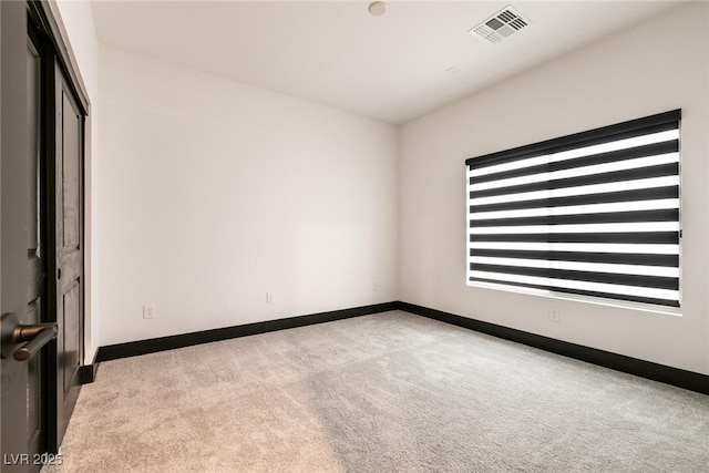 empty room featuring carpet flooring, baseboards, and visible vents