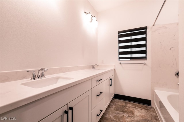 full bathroom with a sink, baseboards, double vanity, and a tub