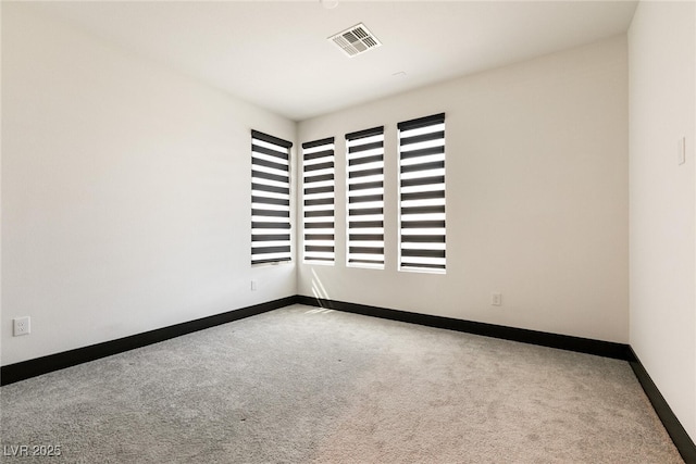 empty room featuring visible vents, baseboards, and carpet floors