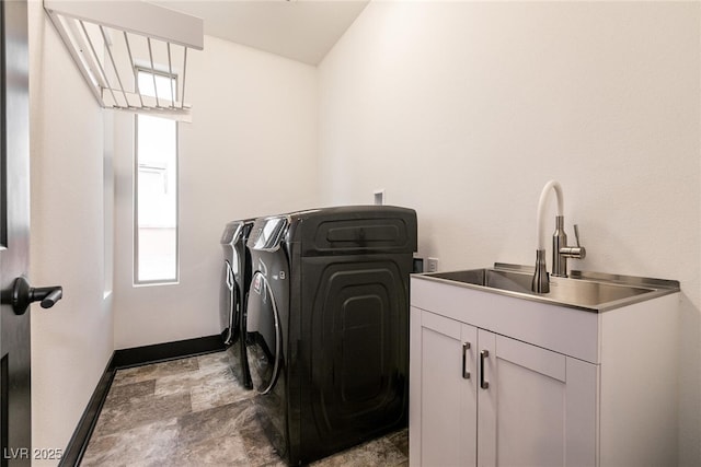 laundry room with a sink, cabinet space, baseboards, and washing machine and clothes dryer