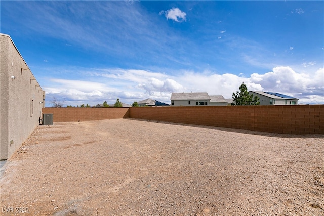 view of yard with a fenced backyard and central AC